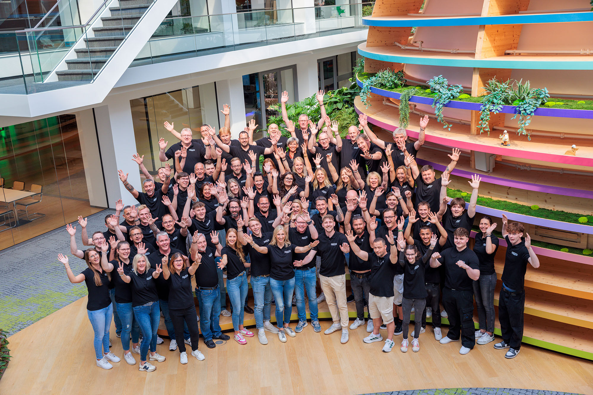 Teambild Ewering alle Mitarbeiter Hände hoch