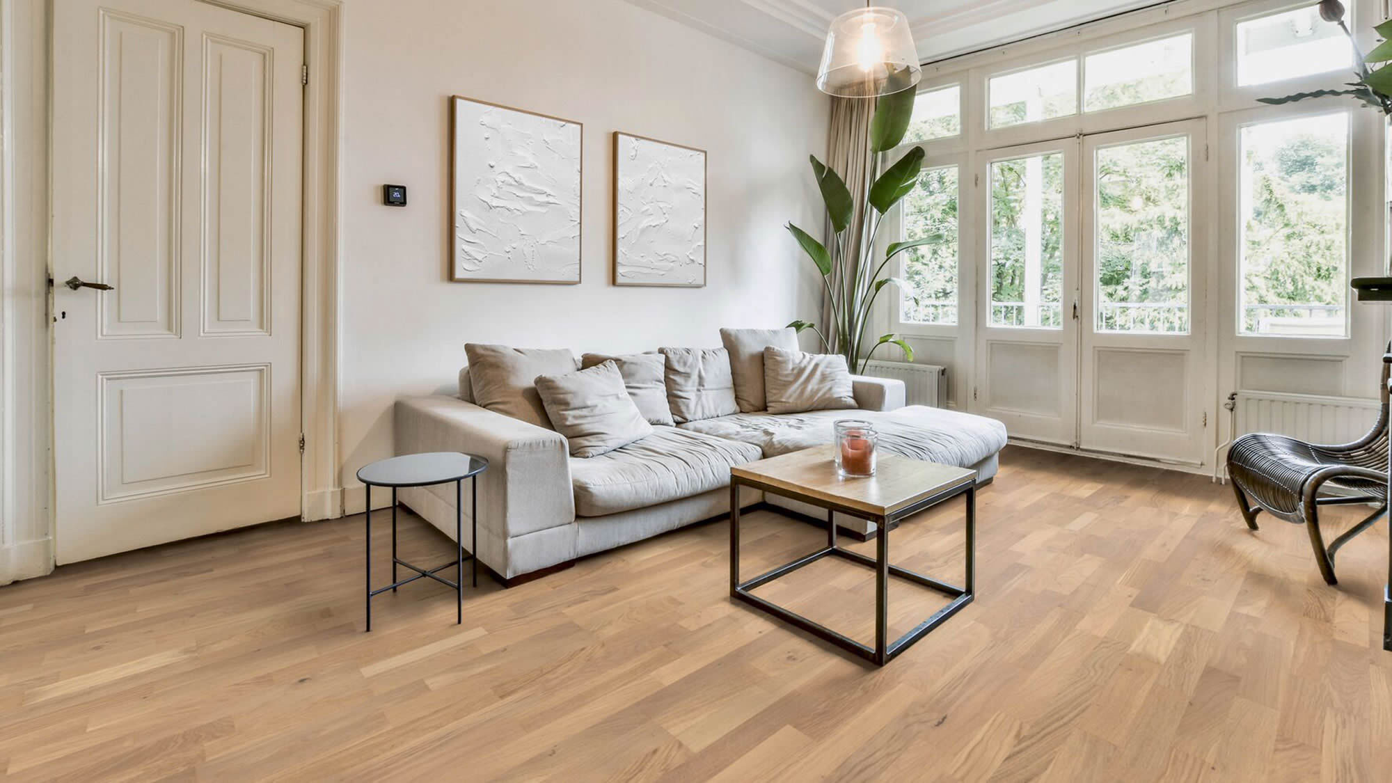 Helles Wohnzimmer mit hochwertig verlegtem Holzboden, großer Fensterfront und ruhiger, wohnlicher Raumwirkung. Das Bild zeigt sauber ausgeführte Bodenbelagsarbeiten in einem stilvollen Wohnraum.