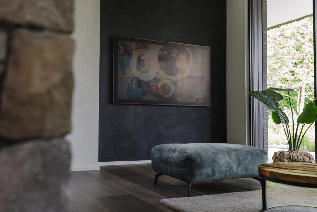 Wohnzimmer mit Frescolori-Akzentwand in fugenloser Spachteltechnik und Sofa - Exklusivarbeiten