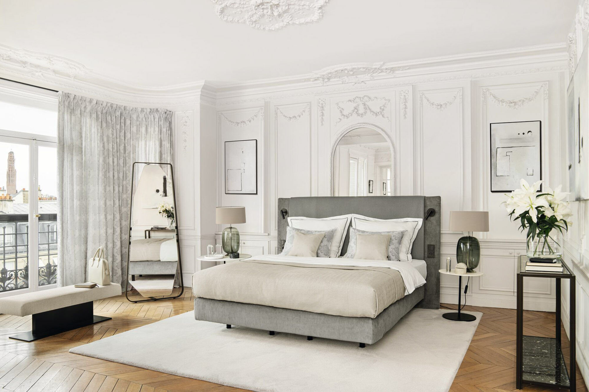 Elegantes Schlafzimmer mit hellem Teppich, hochwertigen Stoffen und einem warmen Holzboden in Fischgrätoptik. Das Bild zeigt ein stimmiges Wohnkonzept mit edlen Materialien, klassischer Raumgestaltung und dem hochwertigen Stil von JAB ANSTOETZ.
