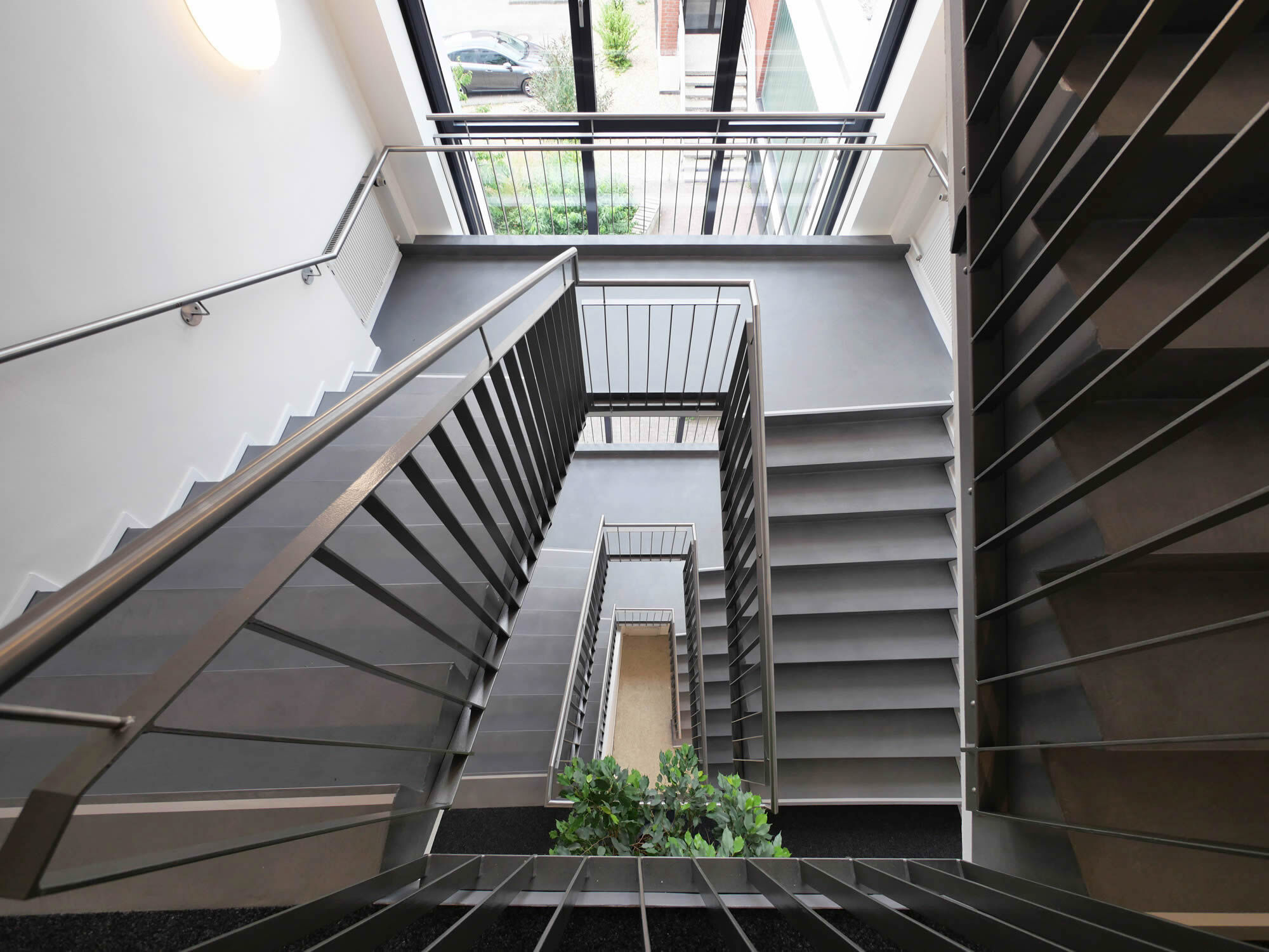 Mehrläufige graue Treppe mit Fensterwand und Metallgeländer von oben, AfA Coesfeld