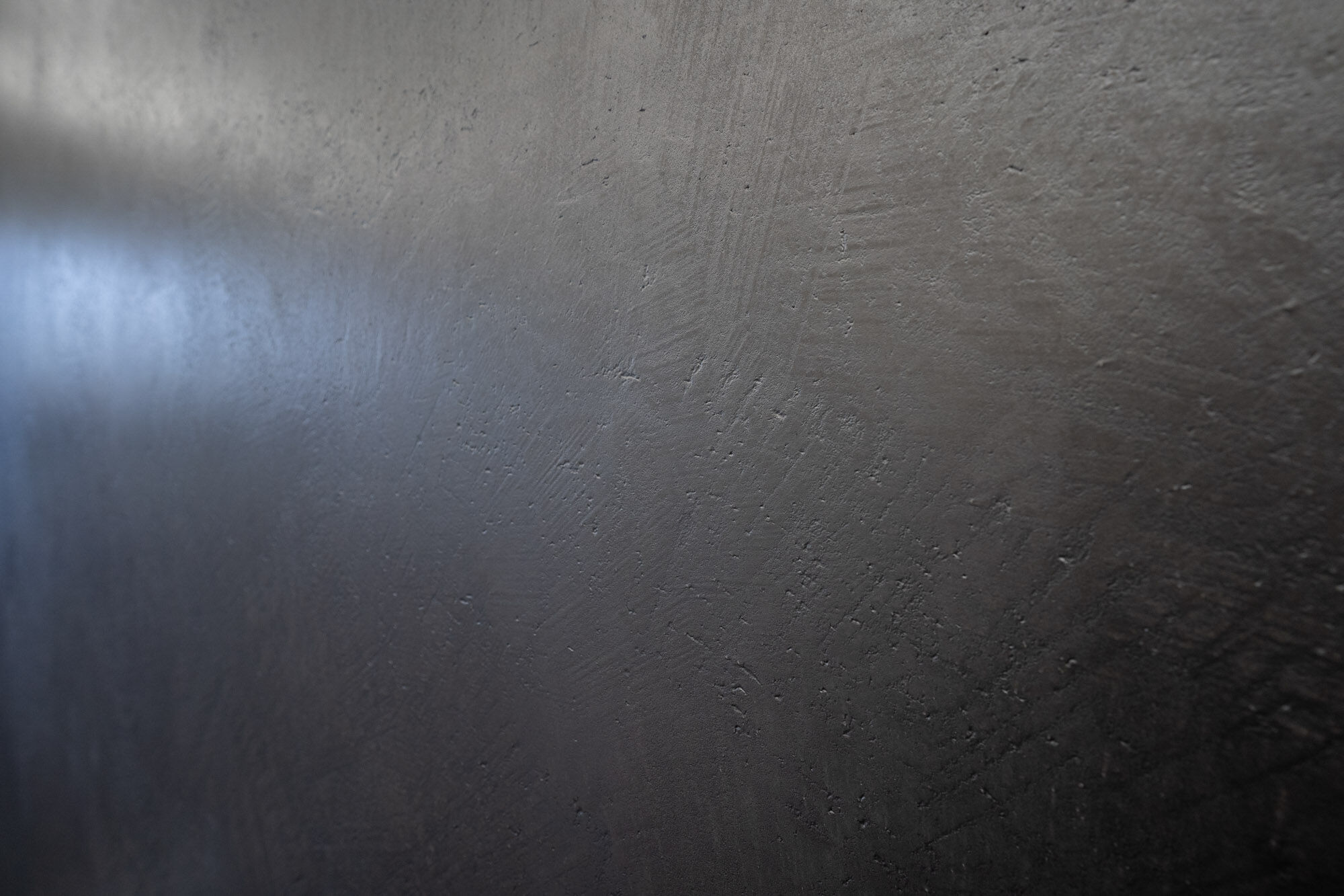 Detailaufnahme einer dunklen Frescolori-Wandoberfläche mit matter Struktur – Exklusives Frescolori-Badezimmer