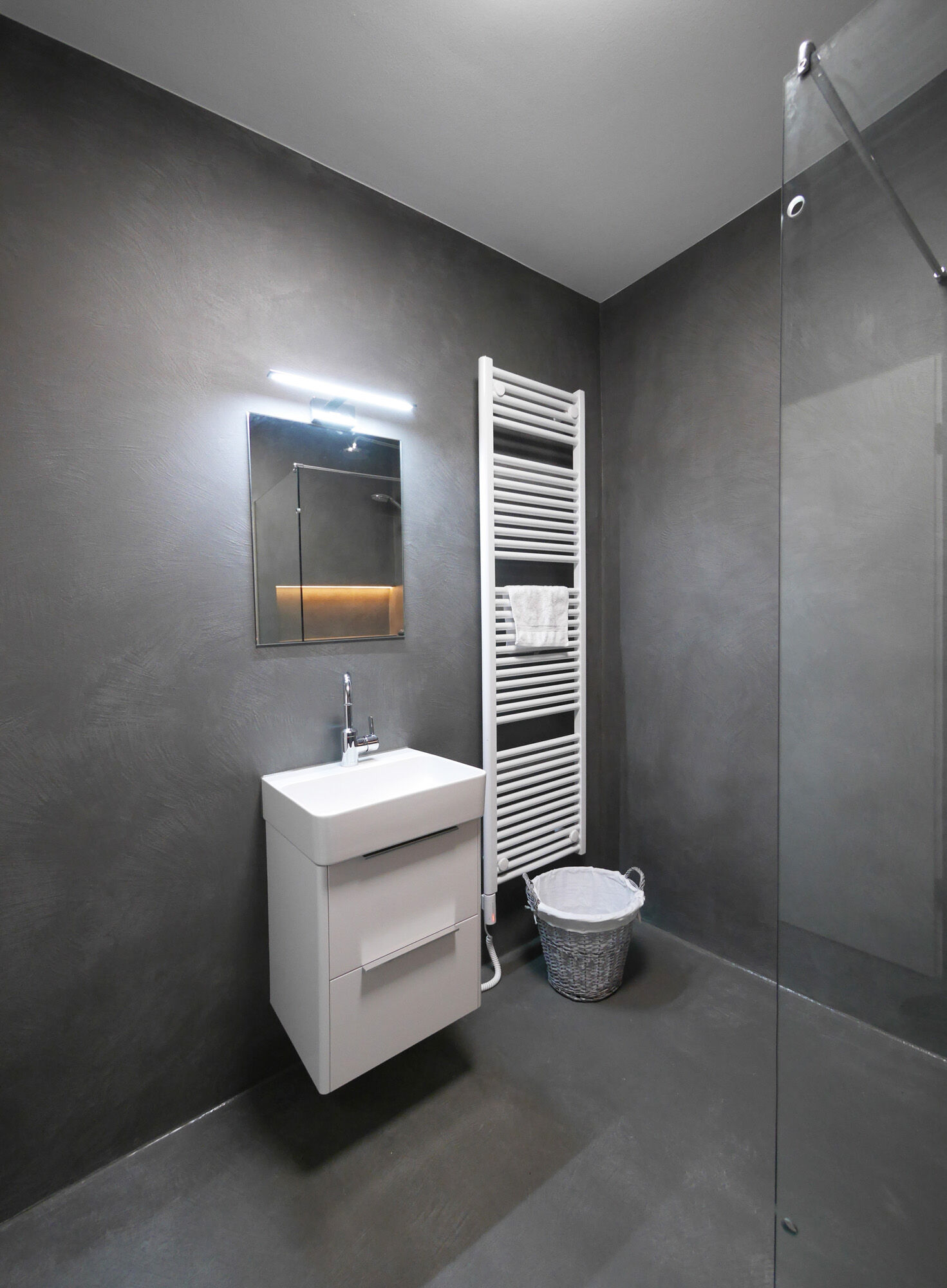 Modernes Duschbad mit dunkelgrauem Waschtisch, LED-Spiegel und Heizkörper – Exklusives Frescolori-Badezimmer