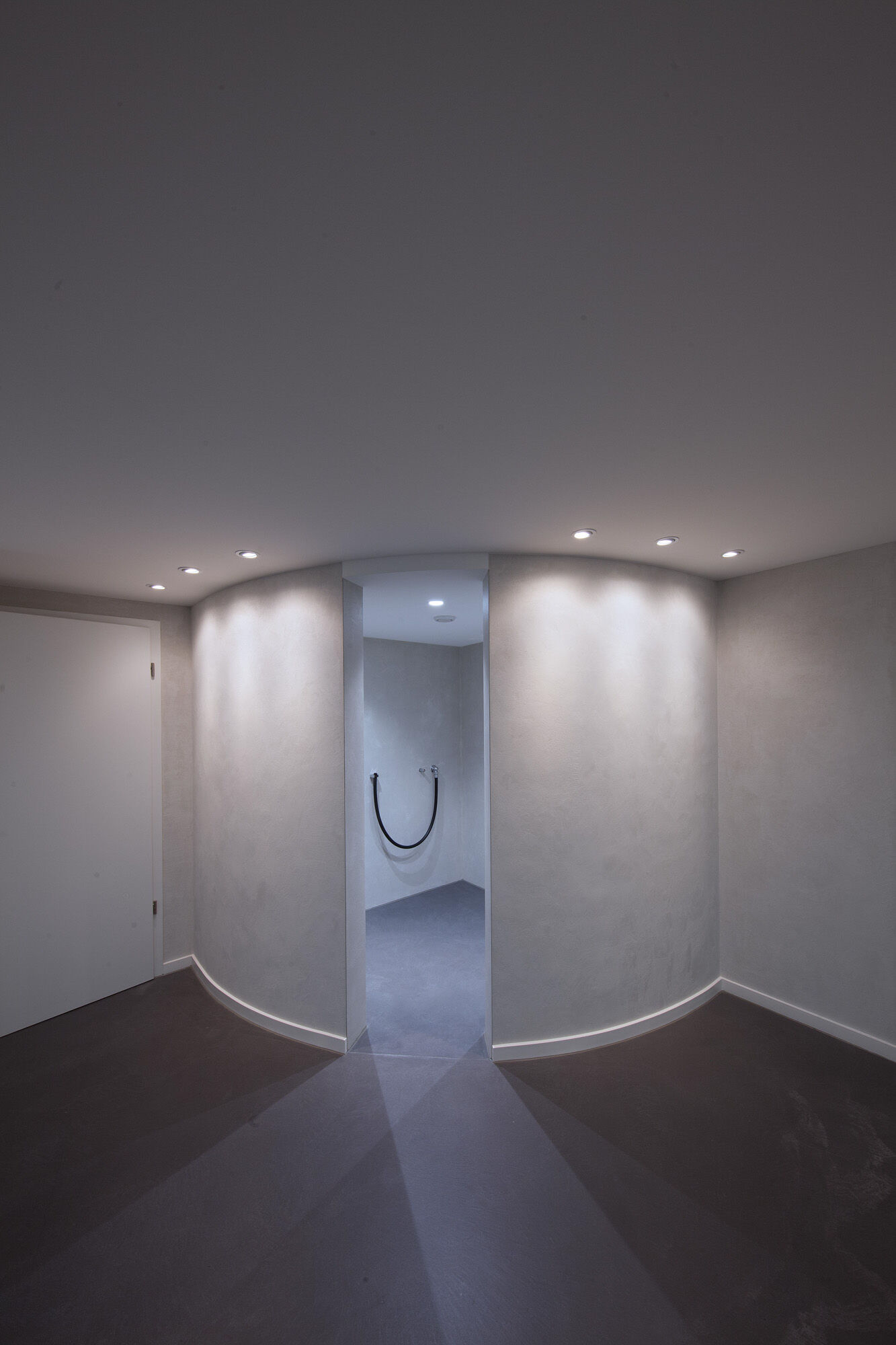 Moderner Wellnessbereich mit geschwungener LED-Wand und Saunaeingang – Exklusives Frescolori-Badezimmer