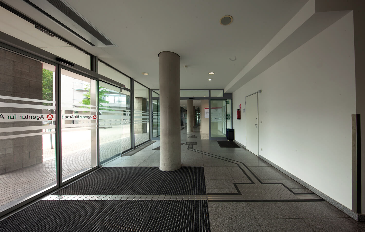 Taktile Leitstreifen und Aufmerksamkeitsfelder im Foyer eines öffentlichen Gebäudes.