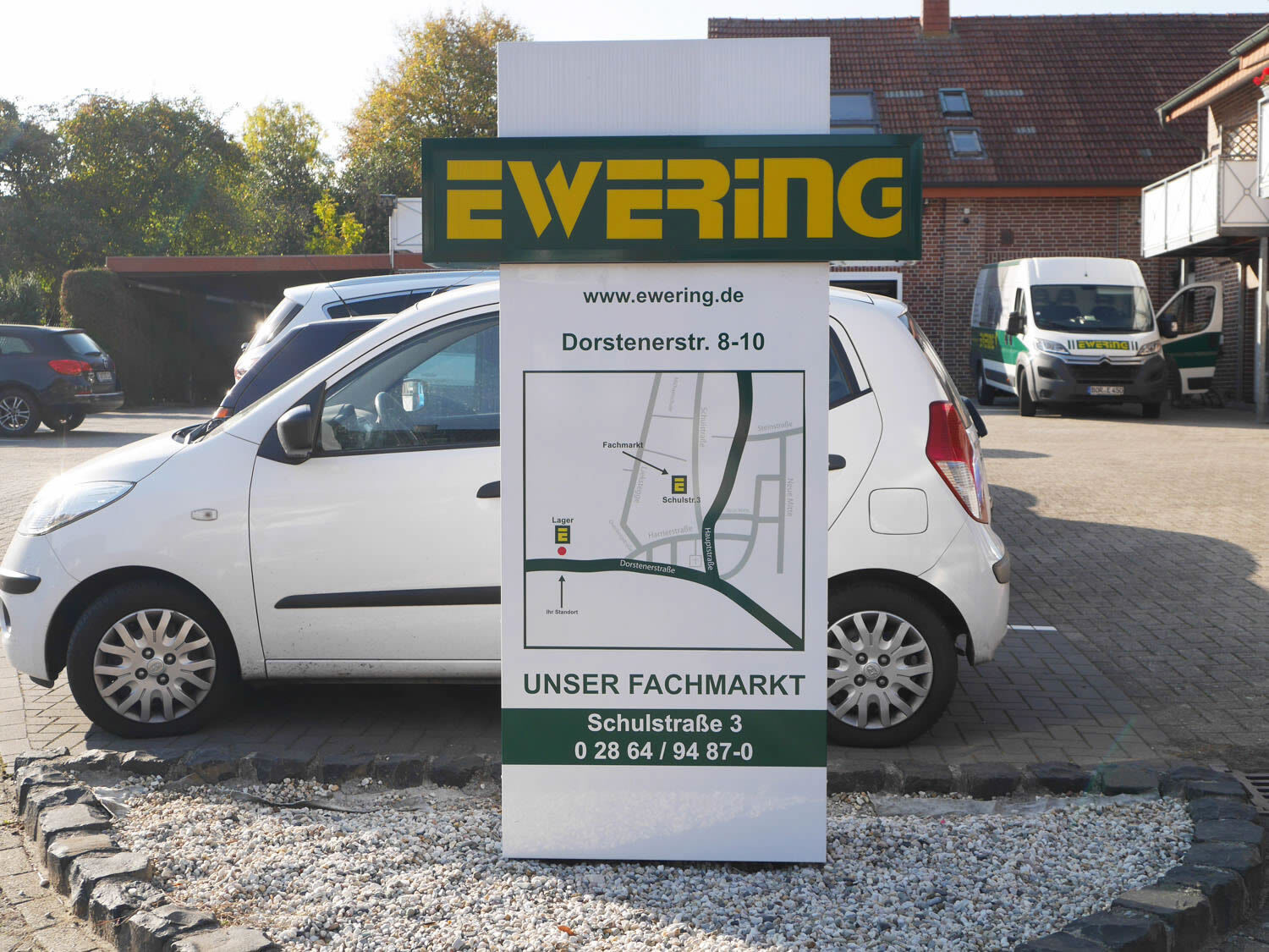 Werbepylon Ewering vor Fachmarkt-Parkplatz mit Lageplan und Adresse - Grafikdesign Werbetechnik Werbepylon