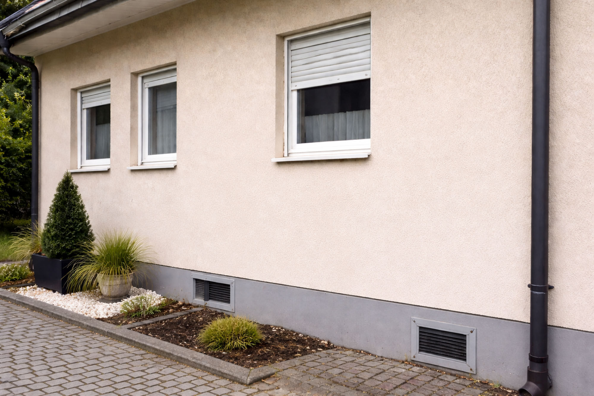 Cremefarbene Hausfassade nach erfolgter Graffitientfernung im Außenbereich - Graffitientfernung