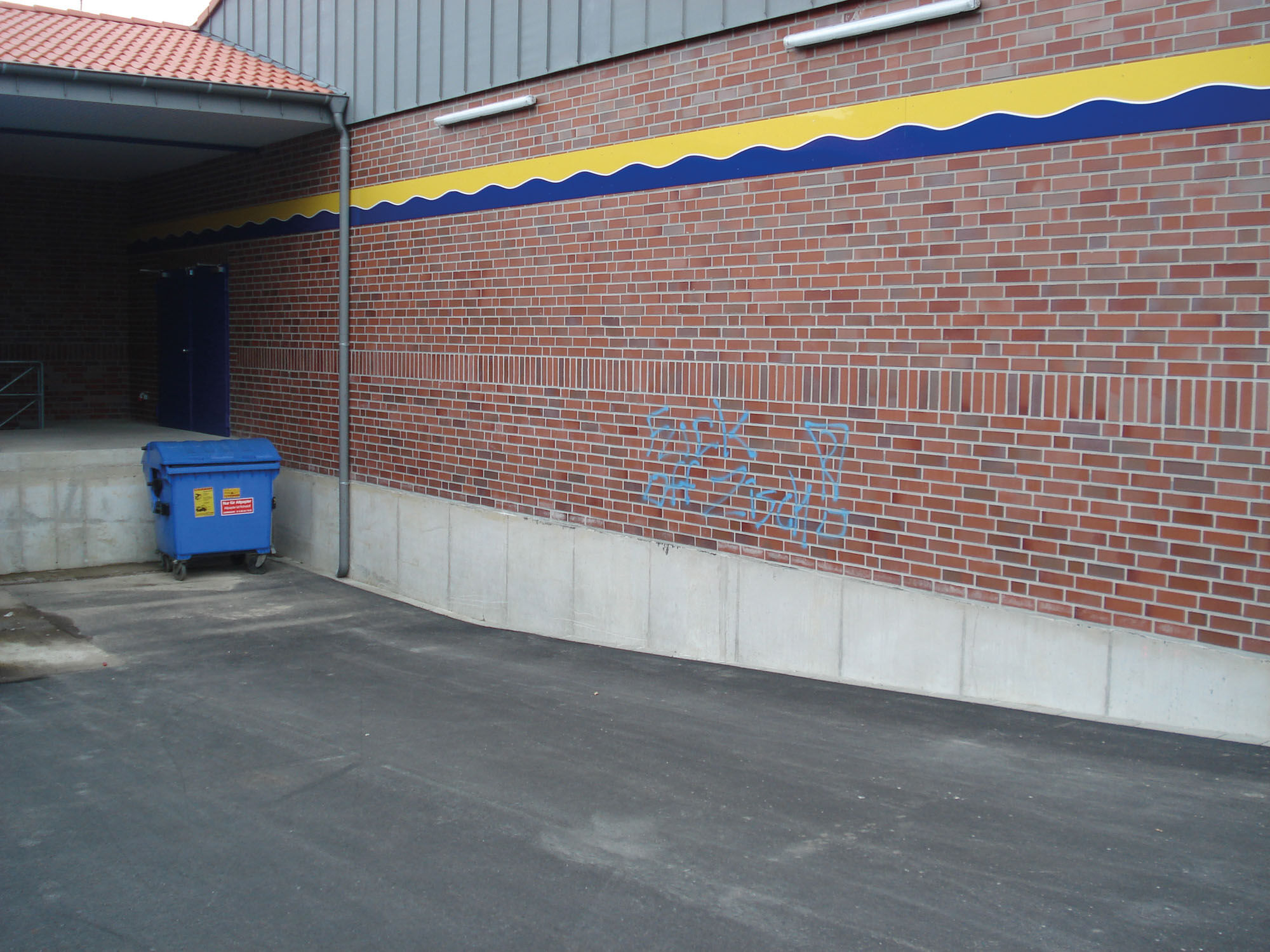 Industriegebäude mit gereinigter Klinkerfassade nach Graffitientfernung - Untergrundreinigung