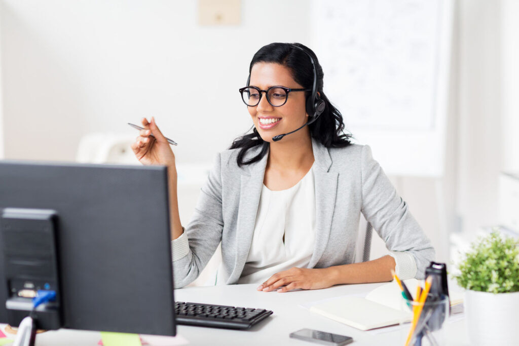 Ewering Mitarbeiterin im Büromanagement mit Headset am Computer